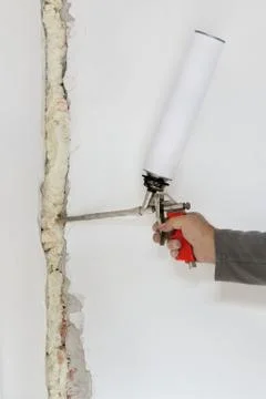 Worker fixing hole in damaged wall Fotos Stock