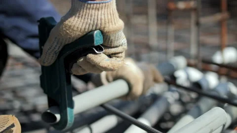 Worker fixing plastic conduit in reinforced concrete Stock Footage 317561711