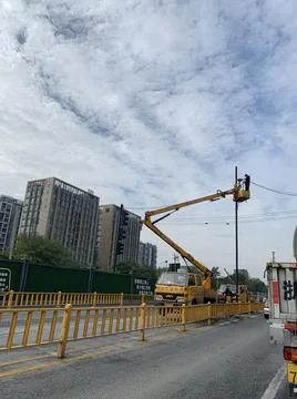 The worker fixing the power lines while standing on the mobile elevating work Stock Photos
