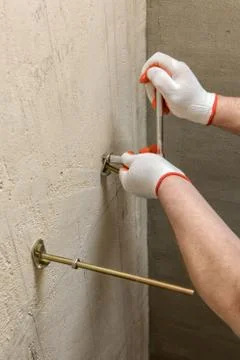 A worker is fixing up a wall of bolts. Foto stock