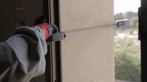 Worker fixing a window with a tool, processing of aluminum parts in a Production Stock Footage 110771426