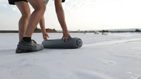 Worker folding synthetic pvc membrane on a flat roof Stock Footage 143149420