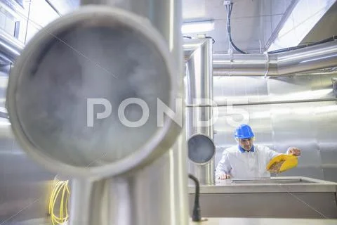Worker In Food Factory Operating Fish Smoking Machine