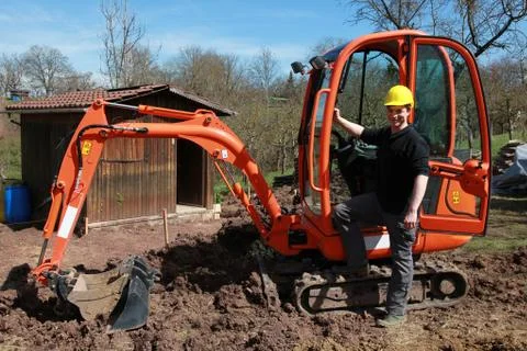 Worker in front of an excavator Stock Photos