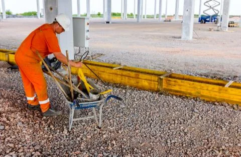 Worker is gathering tools, shovel, and rake in wheelbarrow at building site Stock Photos