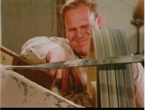 A worker gets his arm caught in a blower machine, falls, and is assisted by Stock Footage 74947933