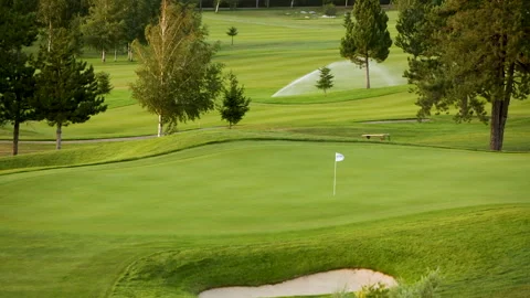 A worker gets into a lawn mower and cuts the grass on a golf course. Stock Footage 262243551
