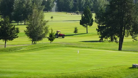 A worker gets into a lawn mower and cuts the grass on a golf course. Stock Footage 263422818