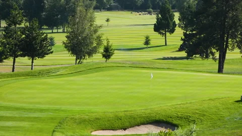 A worker gets into a lawn mower and cuts the grass on a golf course. Stock Footage 263921035
