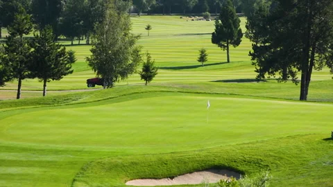 A worker gets into a lawn mower and cuts the grass on a golf course. Stock Footage 263921354