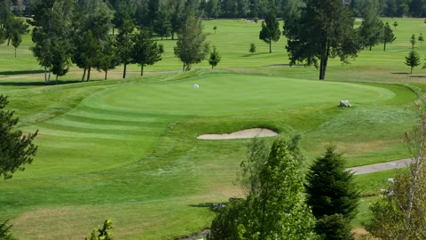 A worker gets into a lawn mower and cuts the grass on a golf course. Stock Footage 264786714