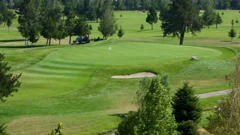 A worker gets into a lawn mower and cuts the grass on a golf course. Stock Footage 265001901