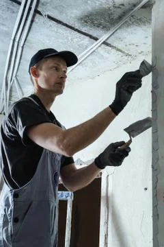 Worker gets plaster on the wall Stock Photos