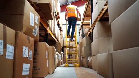 Worker Getting Box Down From Top Shelf Stock Footage 156499362
