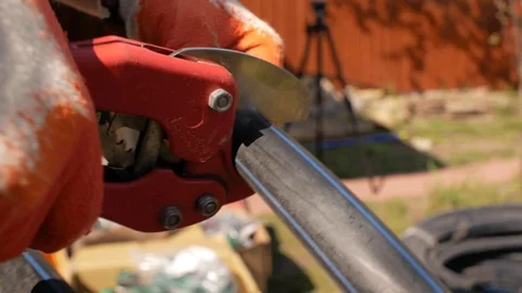 Worker in gloves cuts plastic pipe with nippers. automatic watering system Видео 107935444