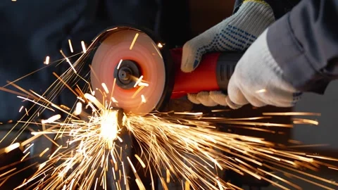 A worker in gloves cutting metal with an angle grinder tool in a workshop Stock Footage 336902682