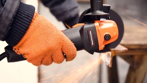 Worker in gloves cutting a metal corner in two pieces with angle grinder Stock Footage 74871774