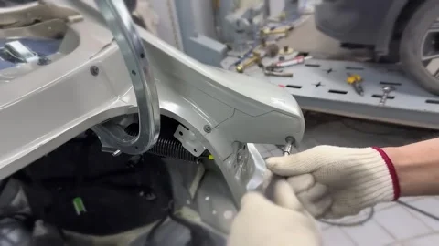 Worker in Gloves Fastening Bolt on Silver Car Fender in Body Shop Vídeos de archivo 348691247