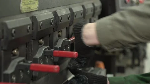 Worker in gloves makes a bend on a metal part using a CNC, close-up. Factory Stock Footage 277594269