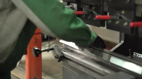 Worker in gloves makes a bend on a metal part using a CNC, close-up. Factory Video stock 277594471