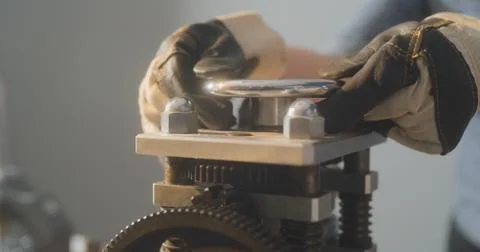 Worker in gloves is twisting some valve using two hands Photos