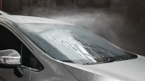 Worker with gloves using hose to wash a vehicle in professional car wash station Stock-Footage 197746109