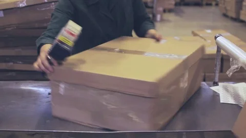 Worker glue tape on the box Stock Footage 76980659