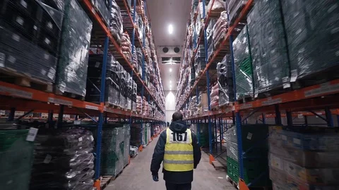 The worker goes between the rows of the warehouse Stock Footage 121189283