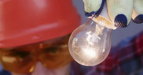 Worker with goggles check lightbulb to ensure proper function. 動画素材 258738702