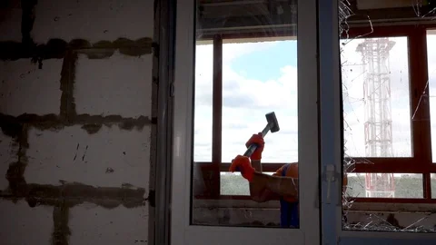 Worker got angry and started breaking windows, vandal breaks a window Stock Footage 115438107