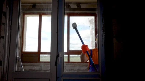 Worker got angry and started breaking windows, vandal breaks a window Stock Footage 115439140