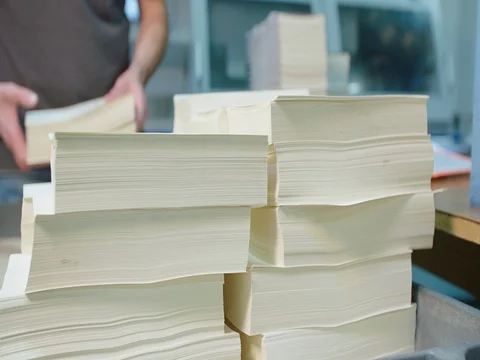 Worker Grabs Stack of Book Pages for Binding Machine Stock Footage 80208429