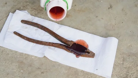 A worker greases old rusty wire cutters. Stock Footage 153308148