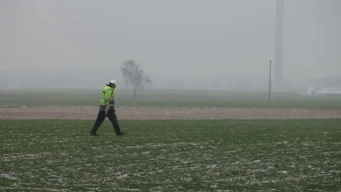 Worker in Green Jacket Walking From Left to Right Stock Footage 72397776