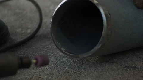 Worker grinding elbow before install with pipe in the workshop Stock Footage 136868035