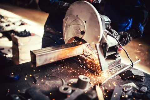 Worker with grinding machine, power tool in factory. Details of cutting steel Stock Photos