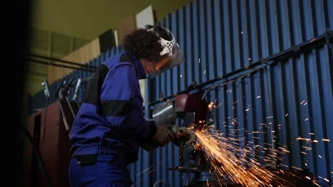 Worker Grinding Metal with Angle Grinder in Industrial Workshop Stock Footage 306682199