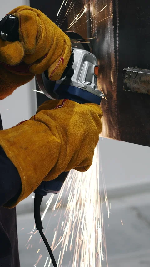 Worker grinding metal with angle grinder producing sparks. Vídeo Stock 347785618