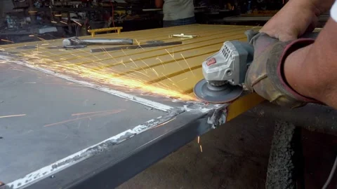 Worker grinding metal sheet with welding sparks Stock Footage 317105893