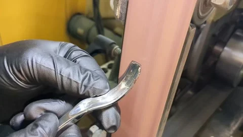 Worker grinding metal surface with mechanical belt sander creating sparks Stock-Footage 344856544