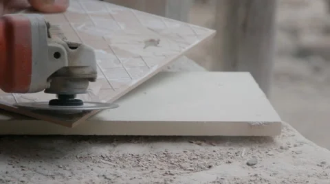 Worker grinding a tile using an angle grinder at construction site Video stock 61863138