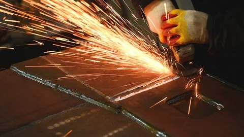 Worker grinding weld seam with grinder machine and sparks Stock Footage 87530589