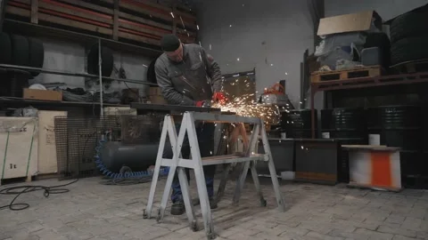 A worker grinds a metal part Stockbeeldmateriaal 225771085