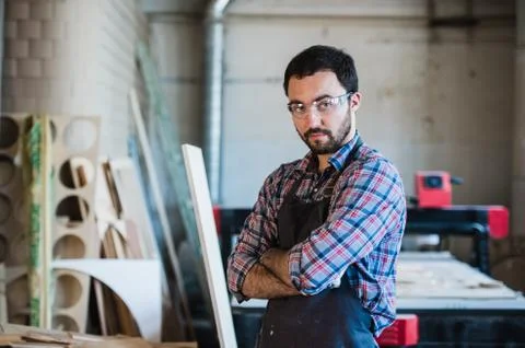 Worker grinds the wood of angular grinding machine Stock Photos