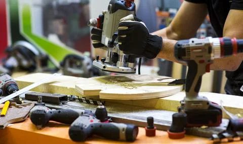 Worker grinds the wood of angular grinding machine Stock Photos