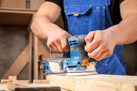 Worker grinds the wood of angular grinding machine 스톡 사진