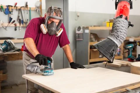 Worker grinds the wood plank of angular grinding machine 스톡 사진