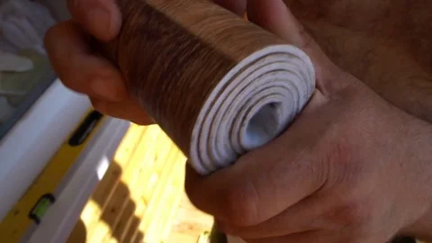 The worker grips the roller in a piece of linoleum Stock Footage 77840239