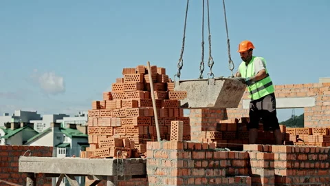 Worker Guides Large Concrete Container Suspended by Crane on Rooftop Stock Footage 312738894