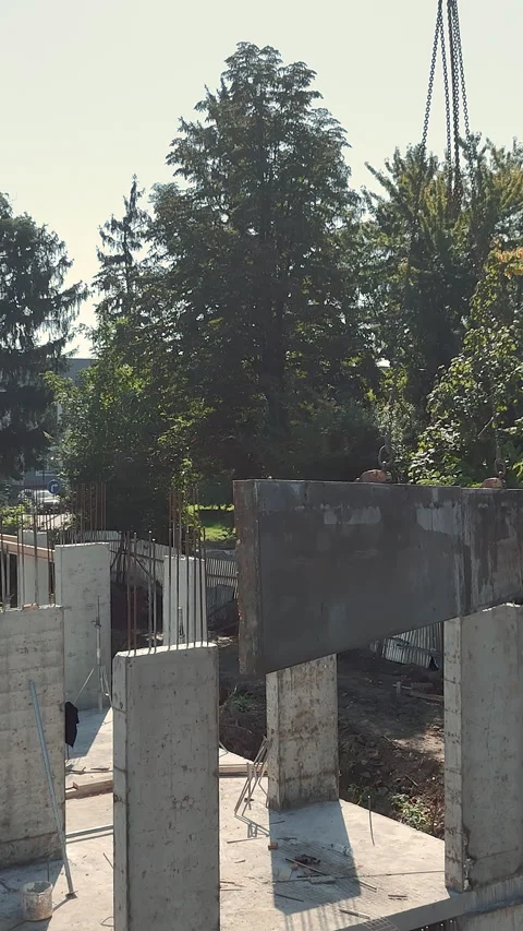 Worker guiding concrete beam installation at construction site. A construction Stock Footage 319840756